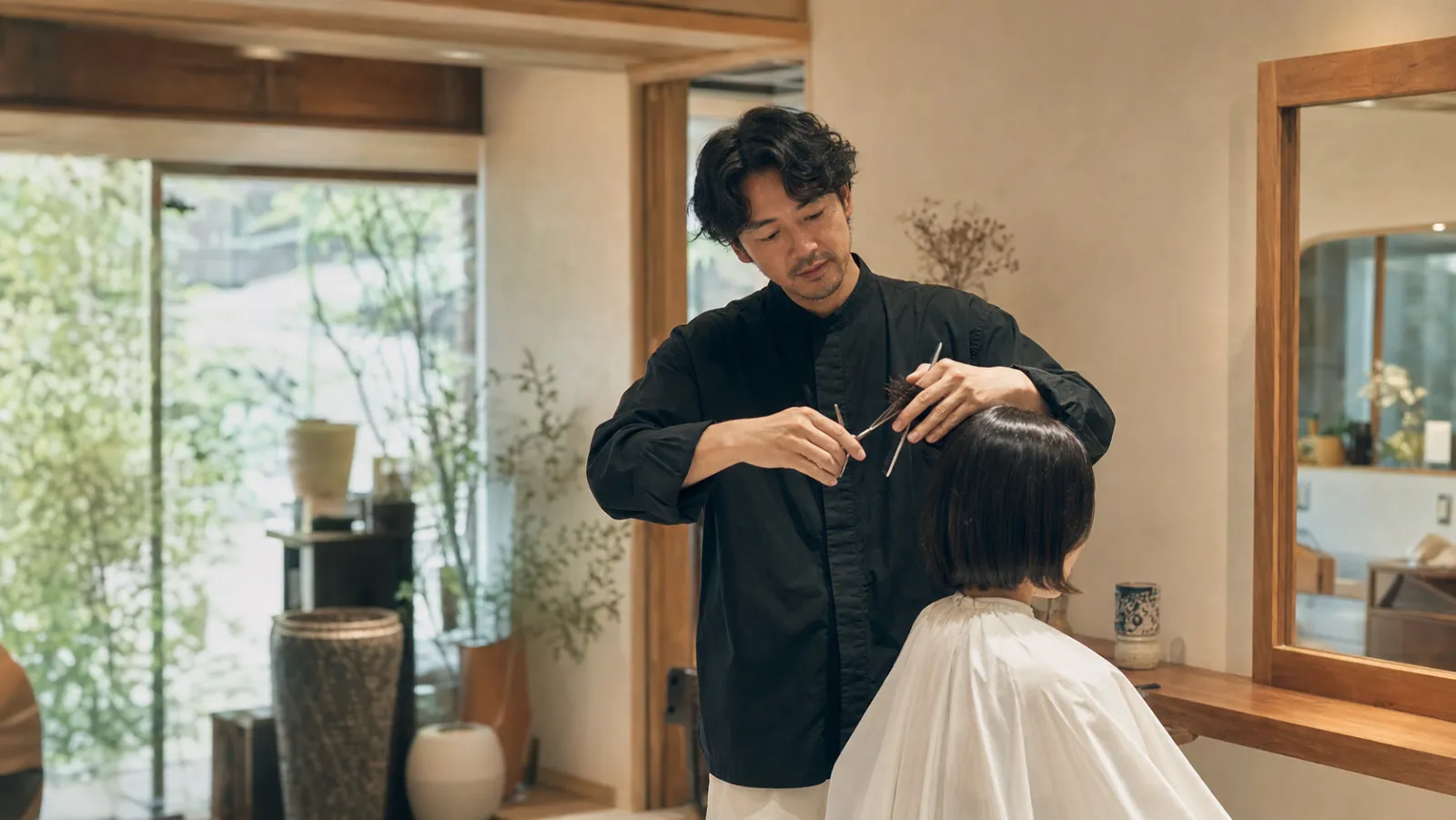 日本人の美容師が髪をカットしている様子